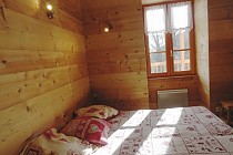 Chalet Milliat - slaapkamer met raam en 2-persoonsbed 2